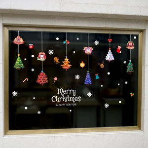 Christmas window stickers with cartoon trees, reindeer, and snowflakes on a store glass pane