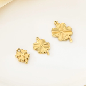 Detailed view of three golden stainless steel four-leaf clover pendants in various sizes