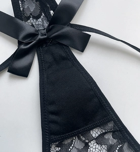 Detail of black eyelash lace texture with satin bow on sexy sheer thong underwear