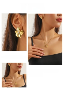 Close-up of gold-plated vintage heart and shell pendant with pearl necklace and earring set