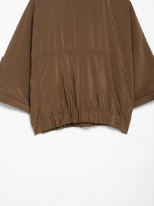 Gros plan détaillé de l'ourlet élastique et de la couture arrière de la chemise brune