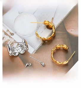 Detail of wavy geometric earrings in gold and silver finish with S925 silver needles