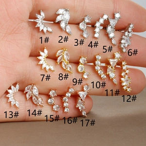 Vue macro de divers clous d'oreilles en zircon en tons argent, or et or rose
