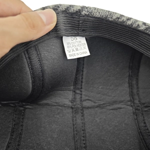 Detailed tag showing size 58 and material blend on grey winter flat cap for elderly men