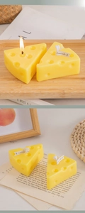 Detailed view of yellow cheese-shaped scented candle on rustic wood and newspaper