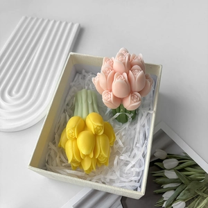 Pink and yellow tulip bouquet candles in a beige gift box with white paper shreds