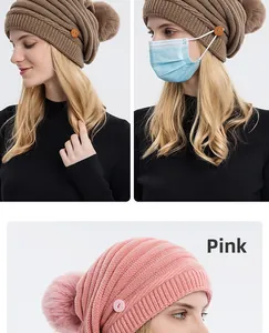 Détail du bonnet en tricot avec double pompon et boutons pour masque en kaki et rose