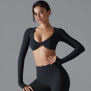 Dettaglio del top da yoga nero a maniche lunghe con nodo a torsione e vestibilità slim
