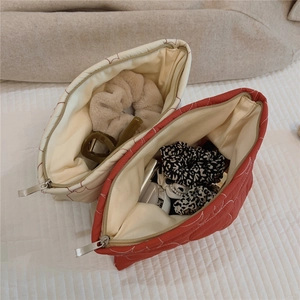 Quilted cosmetic bags in red and beige showing spacious interior for hair accessories