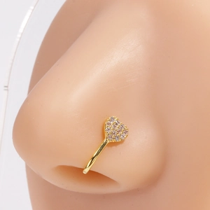 Gros plan d'un faux piercing de nez en cœur doré serti de zircons sur un modèle