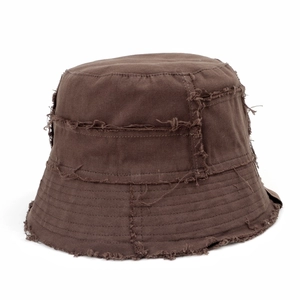 Detailed close-up of distressed edges and frayed fabric on a dark brown canvas bucket hat