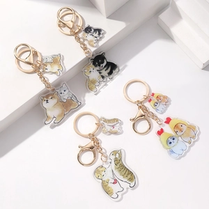 Set of four cute acrylic animal keychains with cats and dogs on white display blocks