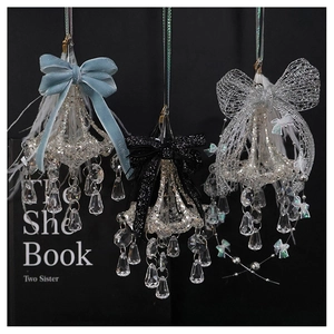 Detailed trio of crystal chandelier ornaments with velvet and sequin bows on black background
