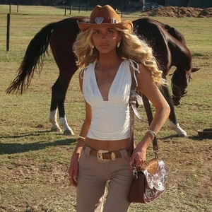 Dettaglio del crop top bianco con scollo a V profondo e vita arricciata stile western