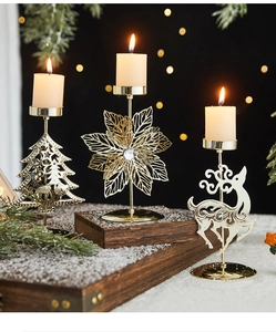 Close-up of golden reindeer and snowflake metal candle holders on a snowy base