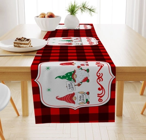 Close-up of red and black plaid Christmas table runner with festive gnome patterns