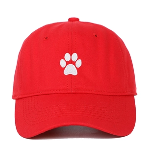 Detailed close-up of a red cotton baseball cap featuring a white paw print embroidery