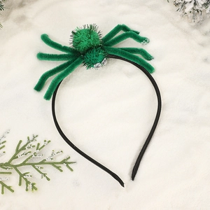 Halloween green plush spider headband on snowy winter background for party decorations