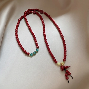 Vintage Chinese style red bead bracelet with a gourd pendant and green stone accents