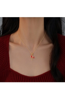 Detailed view of gold plated horse pendant with red enamel on a delicate necklace