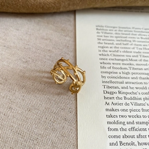 Detailed close-up of golden hollowed heart ring on vintage linen with soft lighting