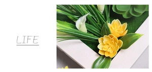 Detail of yellow and white artificial flowers in a white wood grain frame wall decor