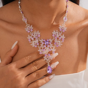 Detail of vintage silver necklace with purple zircon flower and water drop pendant