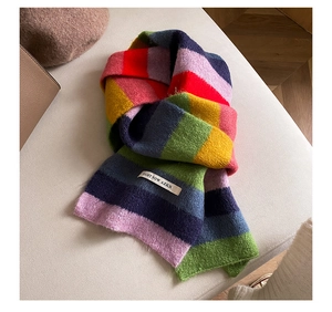 Close-up of rainbow striped mohair scarf showing knit texture and white fabric label