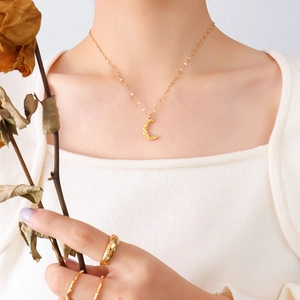Gold hammered moon pendant necklace with delicate chain and matching gold rings