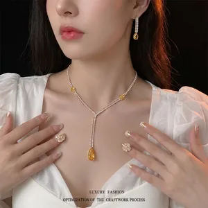 Luxury silver jewelry set with yellow pear-cut zircon necklace and drop earrings on model
