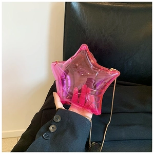 Detailed macro view of pink translucent star-shaped acrylic bag with gold metal chain strap