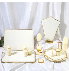 Macro detail of cream velvet jewelry display set with elegant gold metal frames