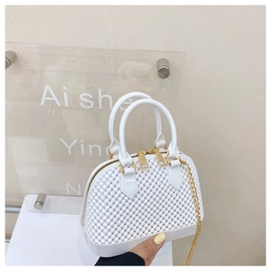 Detail of white PVC jelly bag with embossed texture, gold zippers and chain strap