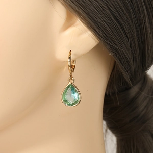 Elegant gold-plated teardrop earrings with mint green crystals on a mannequin model