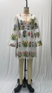Detailansicht der Blumenstickerei und des Netzgewebes an einem weißen V-Ausschnitt Kleid