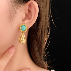 Gros plan de boucles d'oreilles vintage triangulaires en turquoise et or