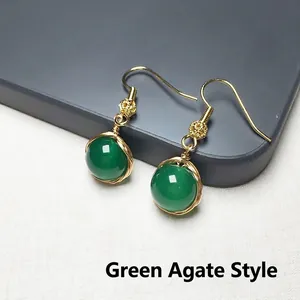 Détail de perles d'agate verte avec fil doré enroulé et crochets d'oreille vintage