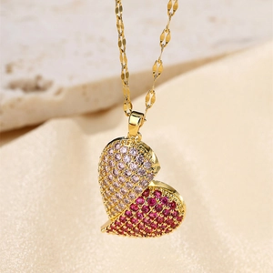 Macro detail of gold heart necklace featuring micro-set pink and dark red crystals