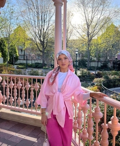 Outdoor portrait of a model wearing a pink patterned 90cm satin scarf and matching outfit