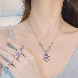 Close-up of luxury pink crystal jewelry set with oval gemstones and diamond halo pavé