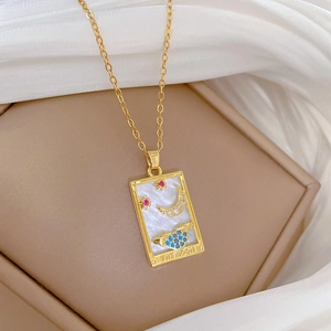 Macro detail of THE MOON tarot necklace with white mother of pearl and colorful zircons