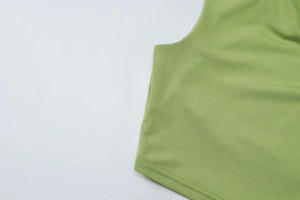 Detail shot of the grass green knitted top showing double stitching and fabric texture