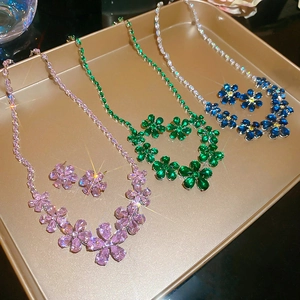 Macro detail of zircon flower necklace and earring set in pink, green and blue