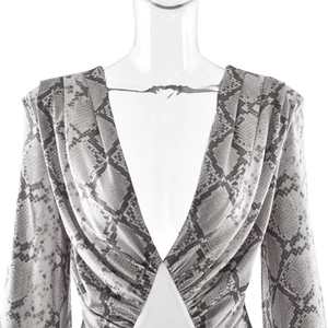 Detail of grey snakeskin print dress featuring deep V-neckline and lantern sleeves