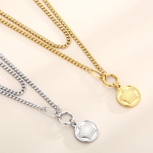 Detail of double-layered necklaces in gold and silver with crown embossed round pendants