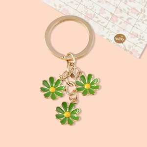 Cute daisy keychain with three green and yellow flowers on gold metal link chains