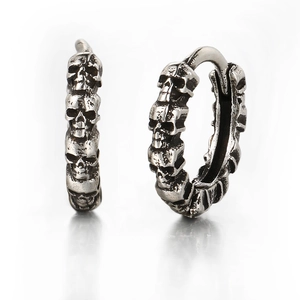 Detailed close-up of retro silver punk skull earrings with vintage embossed texture