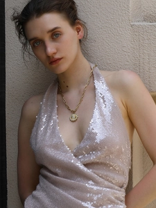 Detail of 18K gold plated stainless steel coin necklace with sunburst star pendant on model