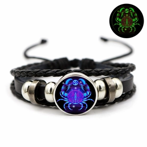 Detailed view of Cancer zodiac leather bracelet showing glowing glass gem and woven cords
