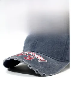 Détail de la visière de casquette vintage avec bords déchirés et broderie rouge usée